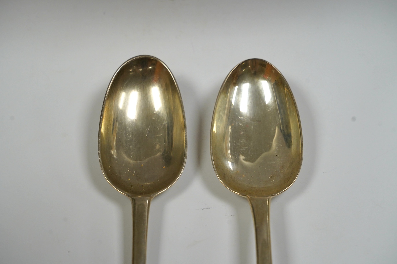 A George I silver Old English pattern table spoon, rubbed maker's mark, London, 1721 and a George III Irish silver table spoon, Dublin, 1760, 136 grams. Condition - fair